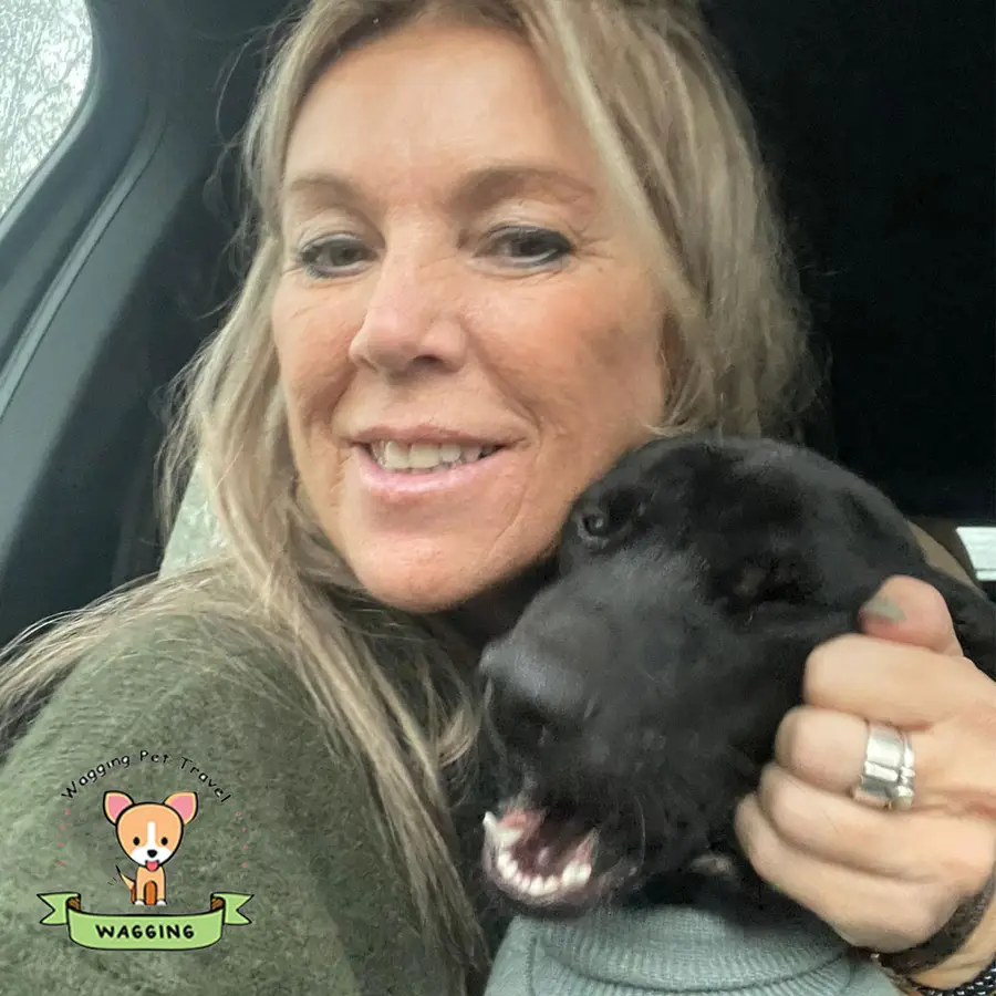 A woman smiling with her black dog