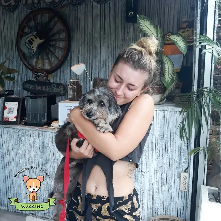 A woman hugging a grey dog